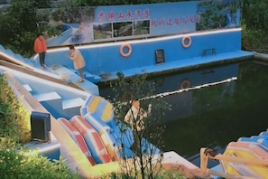 A water slide with a blue structure and a person at the top.