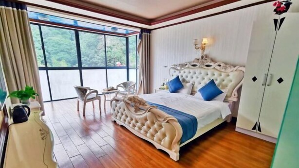 Ein Schlafzimmer mit einem großen Bett, einem Sessel, einem Schreibtisch und einem Kleiderschrank.
