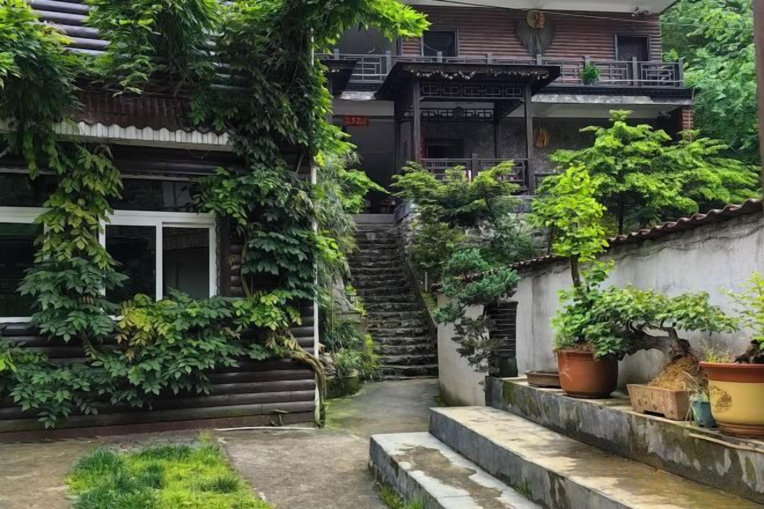 A traditional Japanese-style courtyard with a wooden staircase, potted plants, and a stone pathway.
