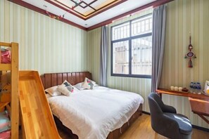 A bedroom with a bed, a desk, a chair, a window, and a bunk bed. - Qingqing Inn (Dali City)