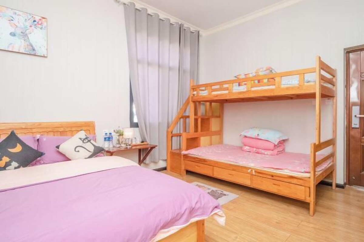 A bedroom with a bunk bed, a single bed, and a nightstand with a lamp.