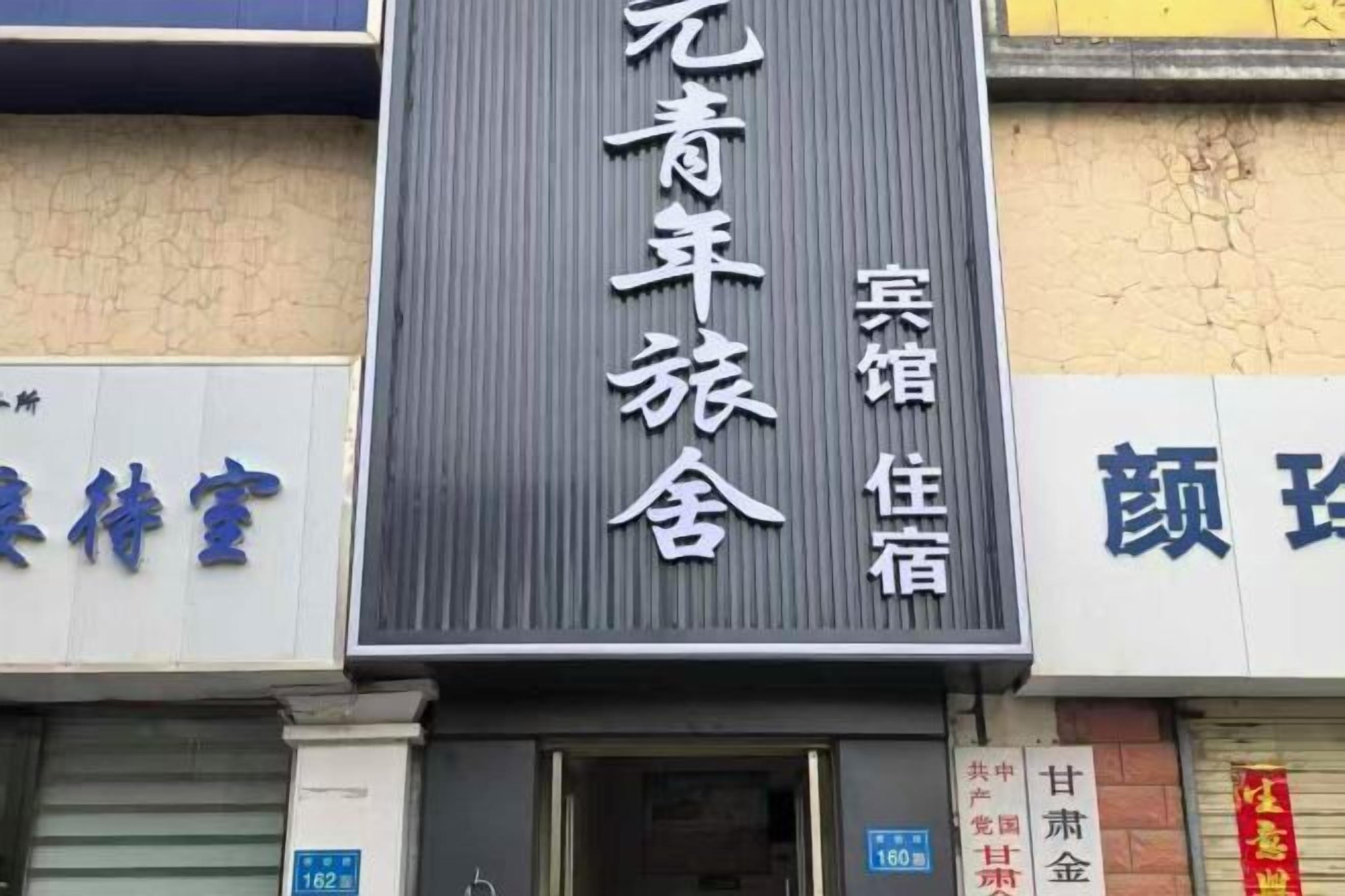 A hotel sign with Chinese characters, indicating the name and possibly the services offered.
