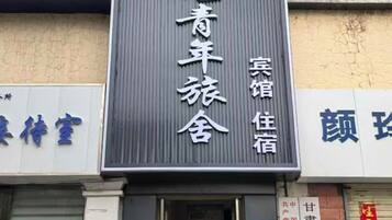 A hotel sign with Chinese characters, indicating the name and possibly the services offered.