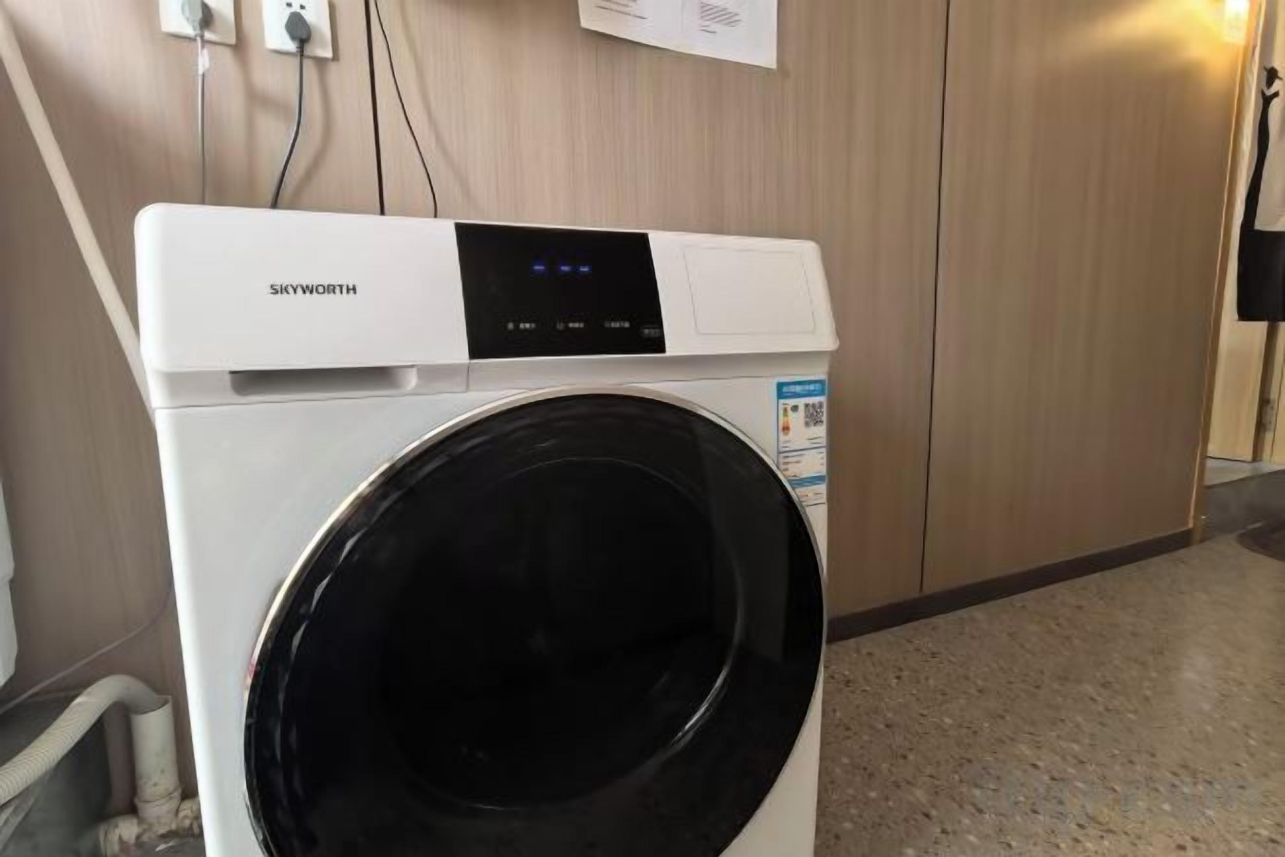 Un lave-linge à chargement frontal de la marque Skyworth dans une chambre d’hôtel.