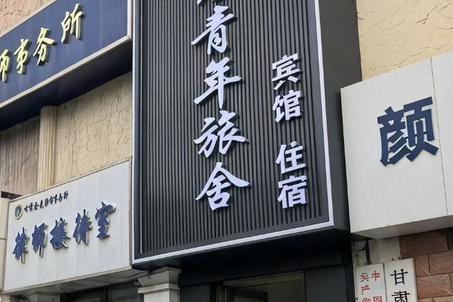 A hotel sign with Chinese characters indicating it is a youth hostel.