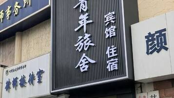 A hotel sign with Chinese characters indicating it is a youth hostel.