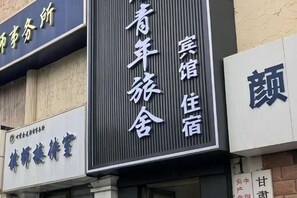 A hotel sign with Chinese characters, indicating the name and possibly the services offered. - XingYuan Hostel (Zhangye)
