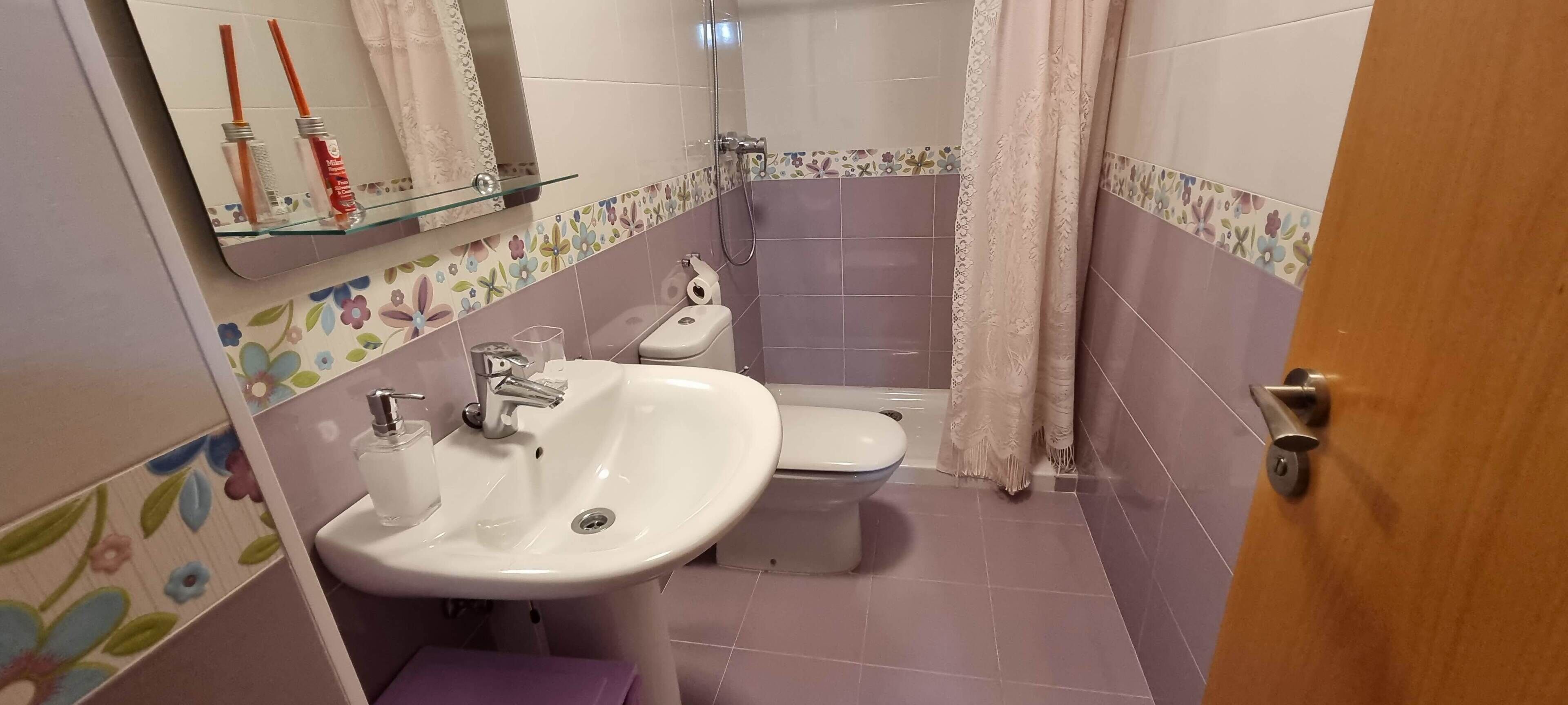 Un baño con lavamanos, inodoro y ducha.