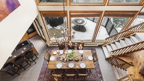 A dining area with a large table, chairs, and a chandelier. - Abode at Highpoint, private hot tub, pool table, mountain retreat (Park City)