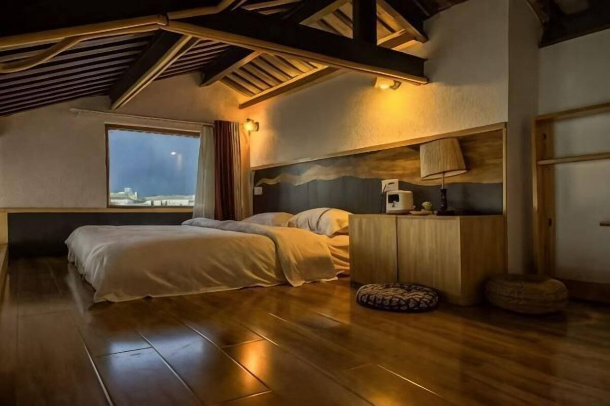 Une chambre à coucher avec un lit, une fenêtre, une lampe et une tête de lit en bois.