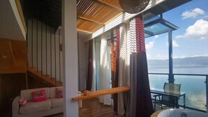 A balcony with a view of the sea, a sofa, and a bathtub. - HillSea Green Holiday Inn , Dali (Dali City)
