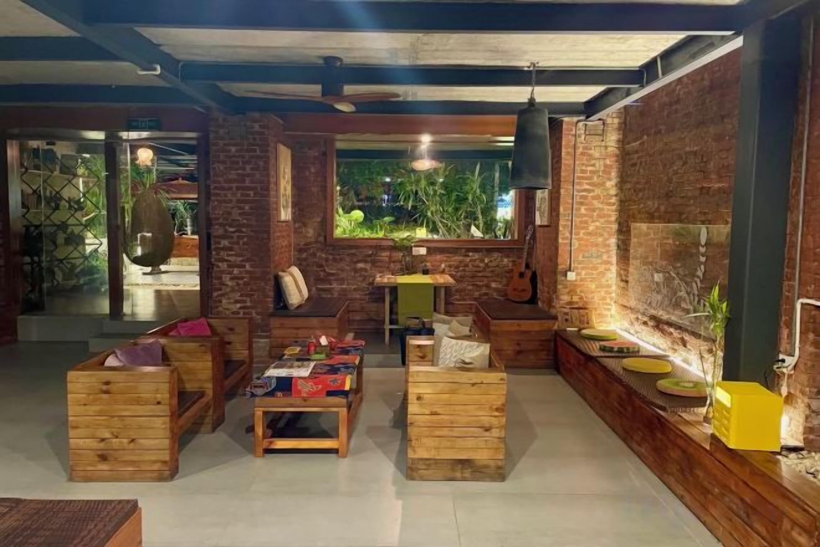 A cozy interior with wooden furniture, a brick wall, and a window with a view.