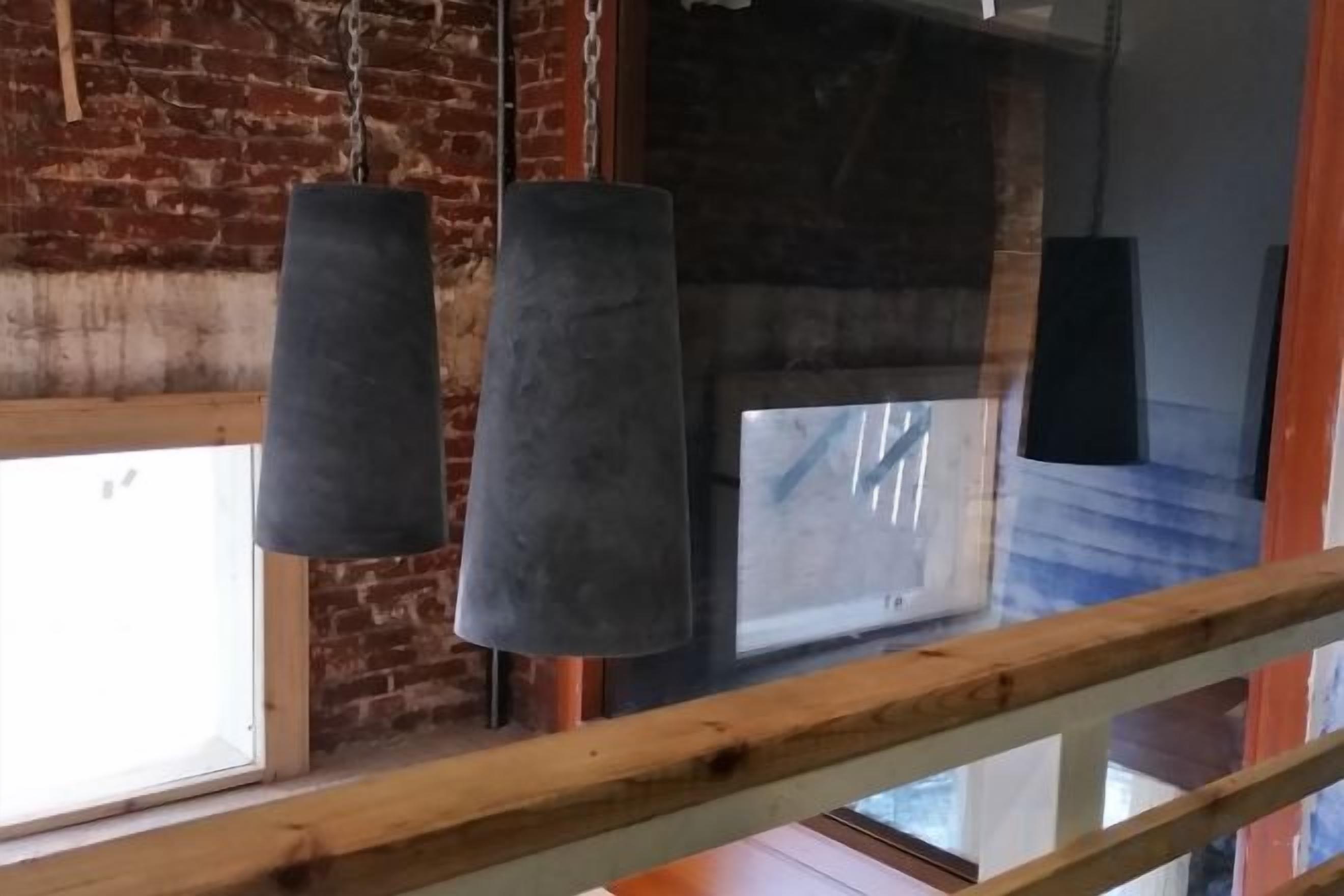 A room with a wooden beam ceiling, a brick wall, and a window with a view.