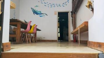 Une pièce avec un bureau en bois, une chaise et un élément de décoration murale aux couleurs vives.