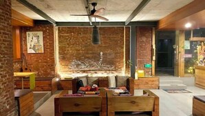 A cozy room with a brick wall, a ceiling fan, and a wooden table with chairs. - Goose city story (Baise)