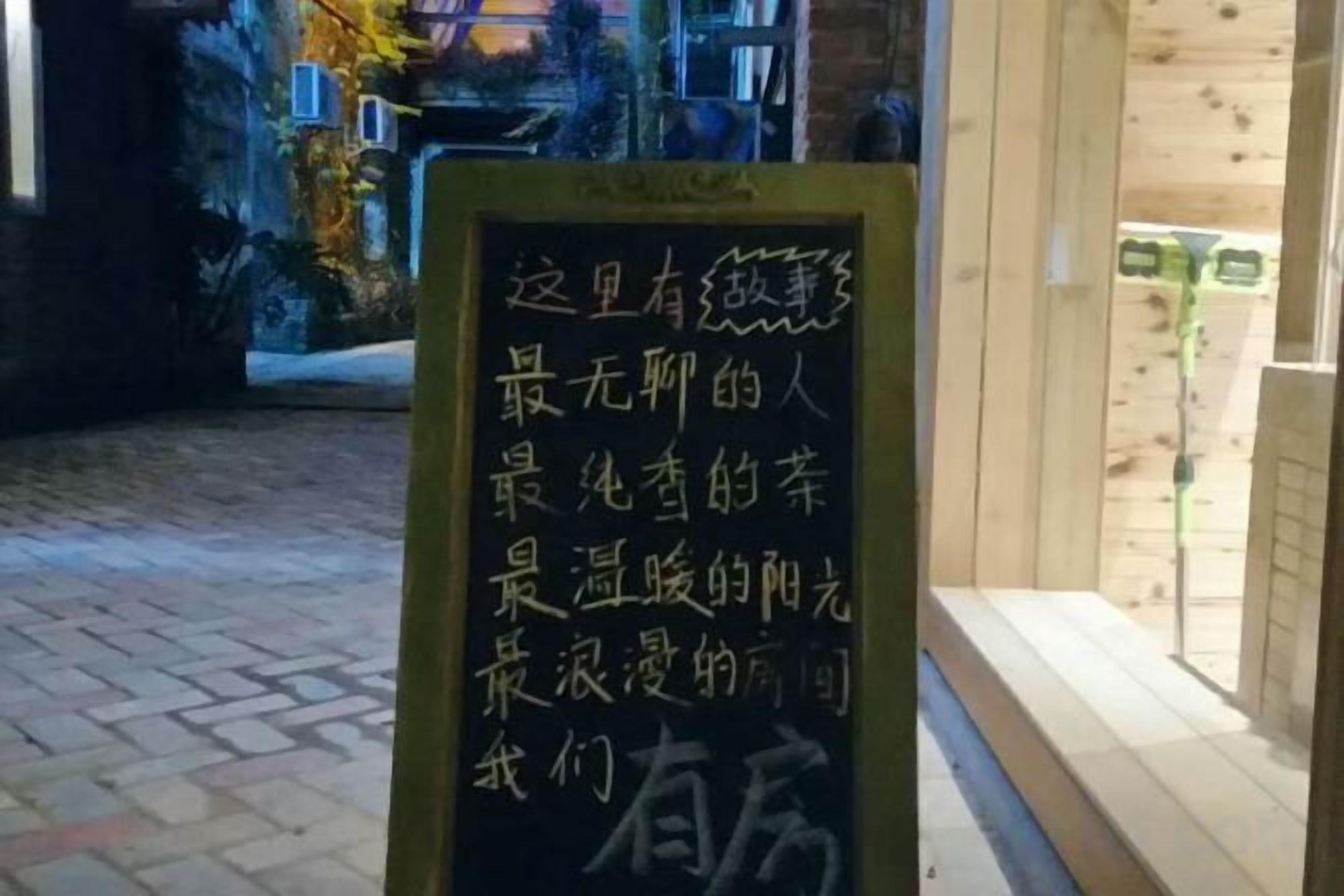 A sign with Chinese characters, a wooden floor, and a building entrance.