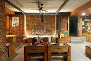 A modern interior with exposed brick walls, wooden furniture, and a ceiling fan. - Goose city story (Baise)