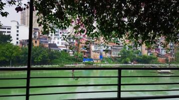 A view of a river with a bridge in the foreground and buildings in the background.