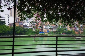 A view of a river with a bridge in the foreground and buildings in the background. - Goose city story (Baise)