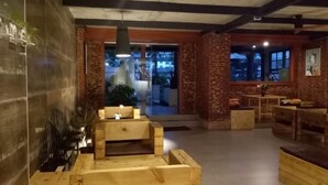 A cozy interior with a wooden bench, brick walls, and a large window offering a view. - Goose city story (Baise)