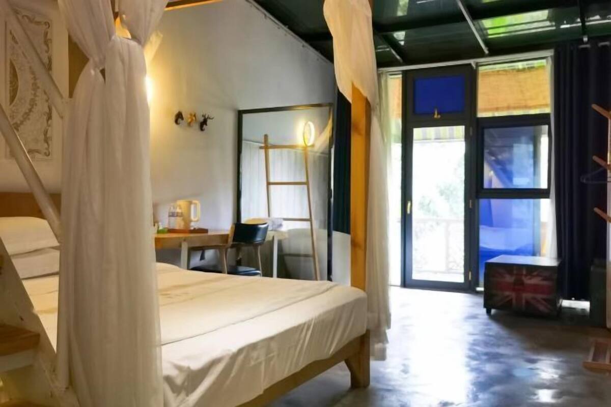 A room with a bed, a desk, a chair, and a ladder.