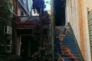 A narrow alley with a staircase leading to a building entrance. - Goose city story (Baise)