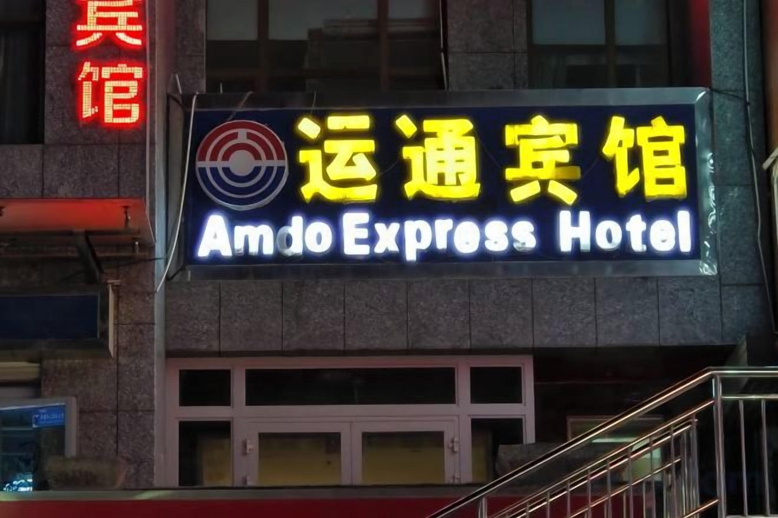 Ein Hotelschild mit der Aufschrift 'Amdo Express Hotel' in englischer und chinesischer Schrift.