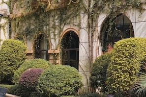 A building facade with arched windows and ivy-covered walls.
