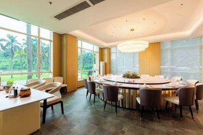A modern dining area with a round table, chairs, and a chandelier. - Hubin Hotel (Foshan)
