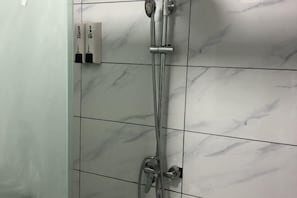 A bathroom with a shower, tiled walls, and a soap dispenser. - Dongmeng Summer Resort (Mengyin)