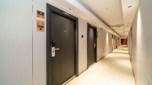A hotel corridor with doors marked with room numbers and a control panel. - Apollo Hotel (Zhangzhou Ancient City) (Zhangzhou)