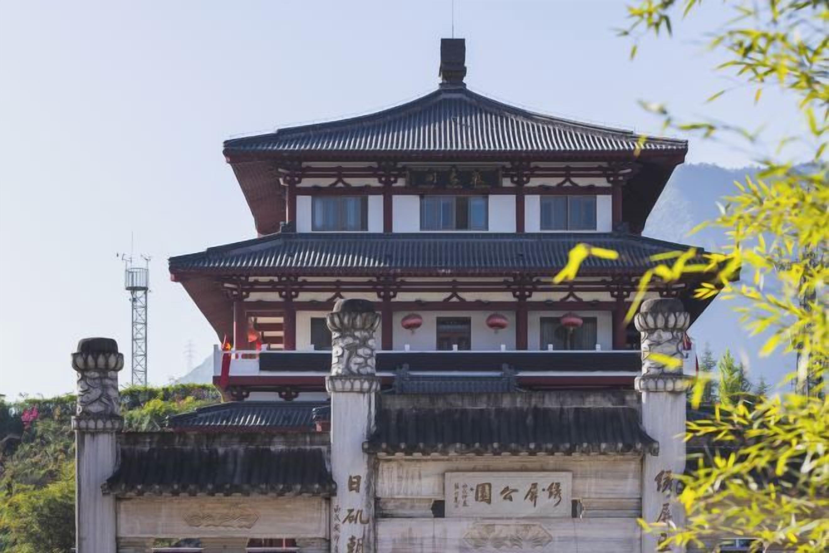 A traditional building with a symmetrical facade, a tiled roof, and a central entrance with a stone base.
