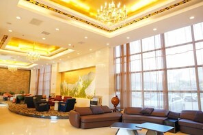 A spacious lobby with a large seating area, a chandelier, and large windows. - Ju Xiu Hotel (Zhen'an)