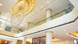 Een meerlaags atrium met een modern ontwerp, inclusief een grote decoratieve lamp en glazen balustrades.