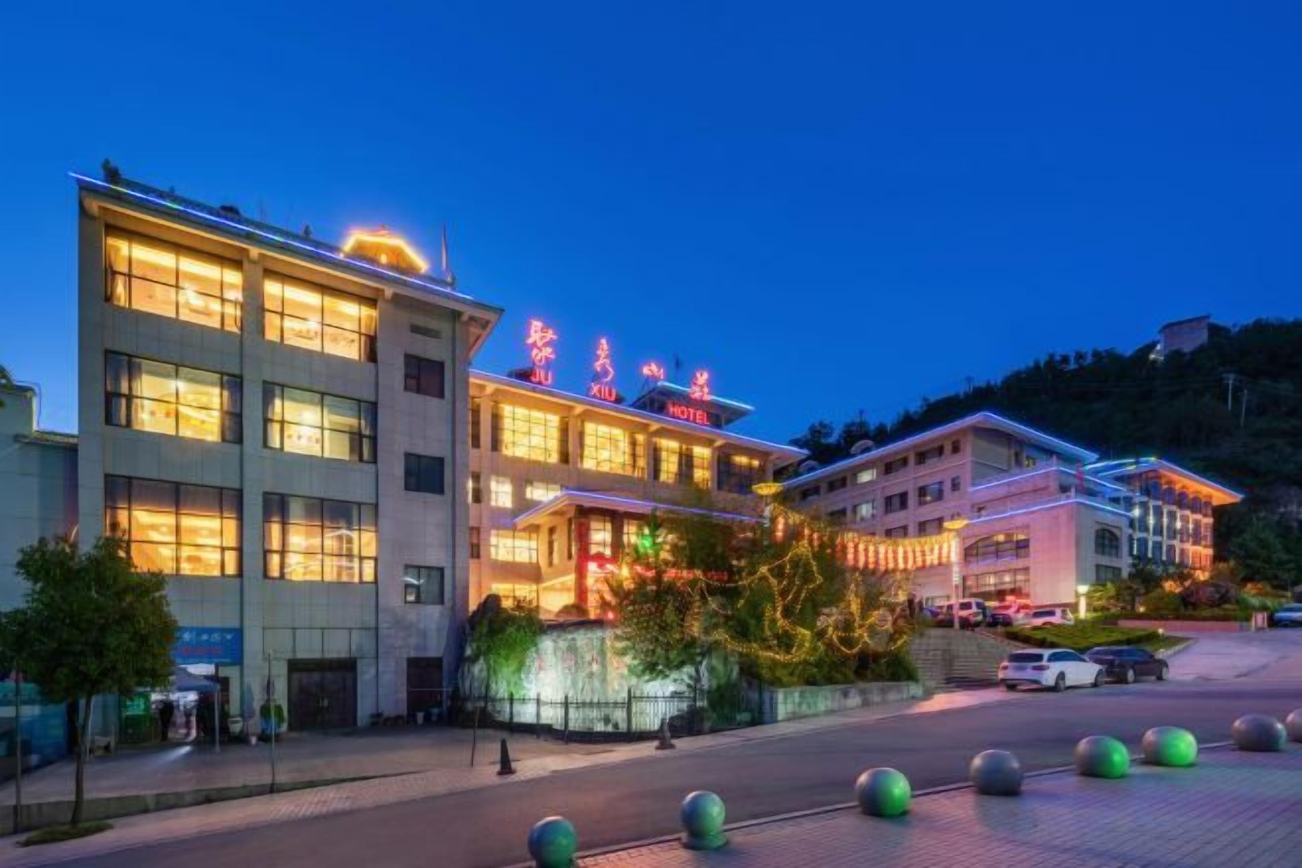 A hotel with multiple floors, a well-lit entrance, and a parking area with bollards.
