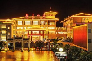 A hotel with a traditional architectural style, featuring a prominent entrance with a red awning and multiple levels of windows. - Ju Xiu Hotel (Zhen'an)