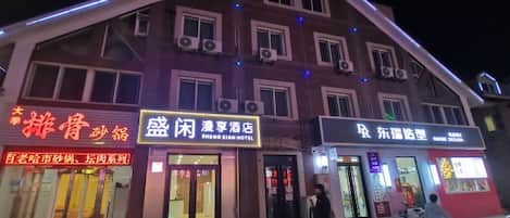 Un edificio con varias fachadas comerciales, que incluye un hotel y un restaurante.