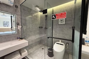 A modern bathroom with a glass shower enclosure, a white sink, and a visible trash bin. - Shengxian Hotel ＆Resorts (Dalian)