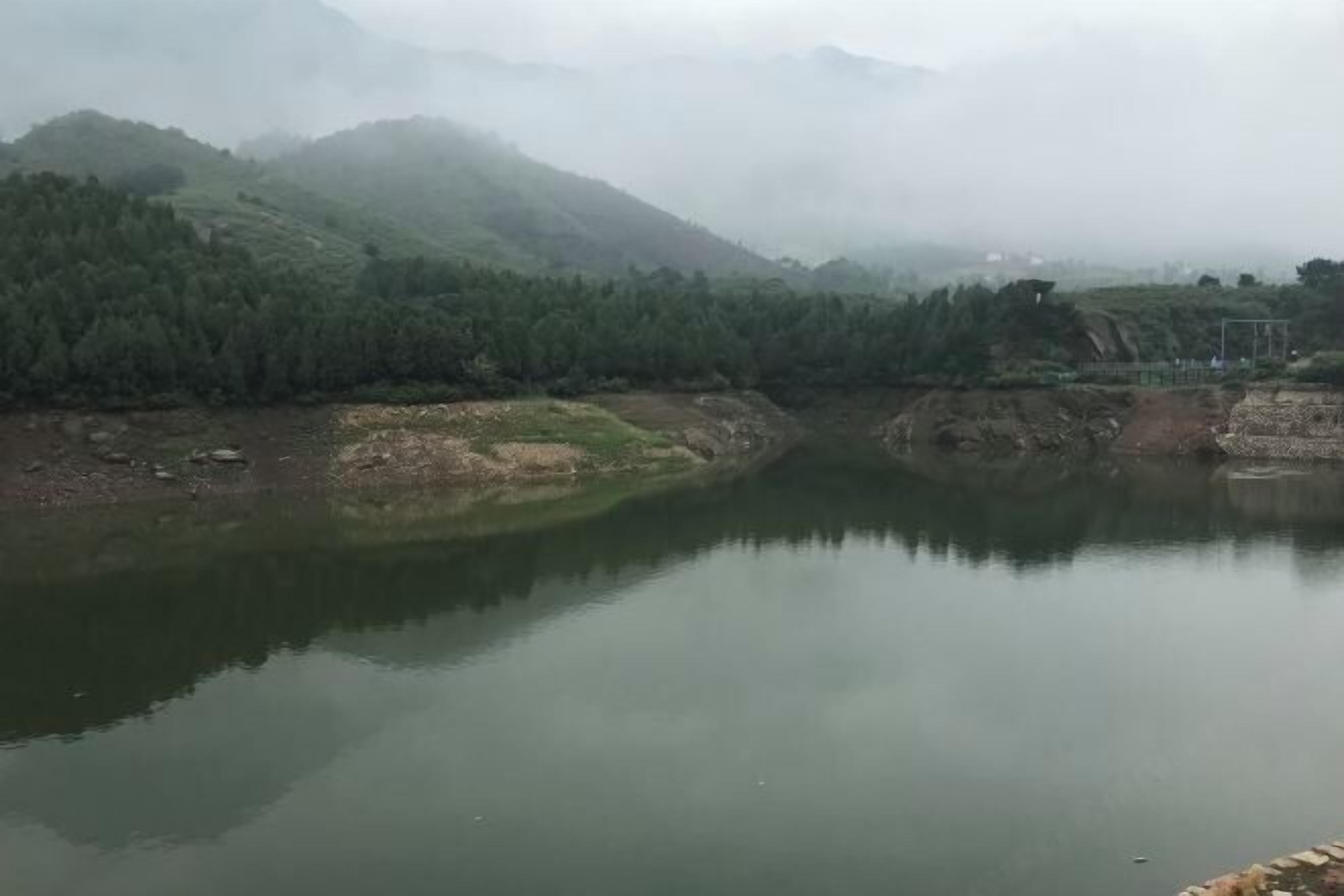 Un río tranquilo con colinas boscosas al fondo.
