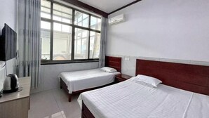 A hotel room with two beds, a TV, a coffee maker, and a window with curtains. - Yuming Farmhouse (Tianjin)