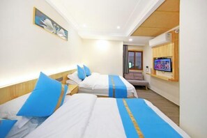 Une chambre d’hôtel avec deux lits, une télévision et un tableau au mur.