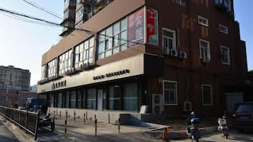 Un edificio de varios pisos con espacios comerciales en la planta baja y viviendas en los niveles superiores.