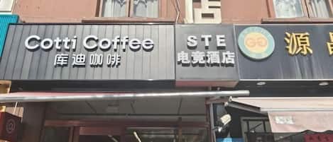 A building with multiple storefronts, including a Cotti Coffee, a STE hotel, and a store with a Go logo.