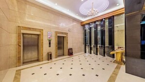A spacious lobby with two elevators, a chandelier, and a patterned floor. - Guangbin Mantiao Hotel (Foshan Lishui Wanli Plaza) (Foshan)