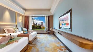 Habitación de hotel con dos camas, un escritorio, una silla, un televisor y vistas a la ciudad.