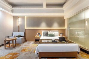 A hotel room with a large bed, a desk, a chair, a nightstand, and a large window. - Guangbin Mantiao Hotel (Foshan Lishui Wanli Plaza) (Foshan)