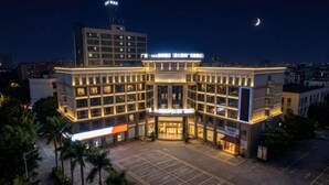 A multi-story hotel with a central courtyard, surrounded by palm trees. - Guangbin Mantiao Hotel (Foshan Lishui Wanli Plaza) (Foshan)