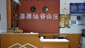 A reception desk with a wooden design and a sign above it. There are two clocks on the wall and a bulletin board with information. - Puyuan Xiangu Hotel (Chishui)