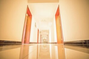 A long, narrow hallway with a polished floor and doors on either side. - Yangguang Express Hotel (Yinan)