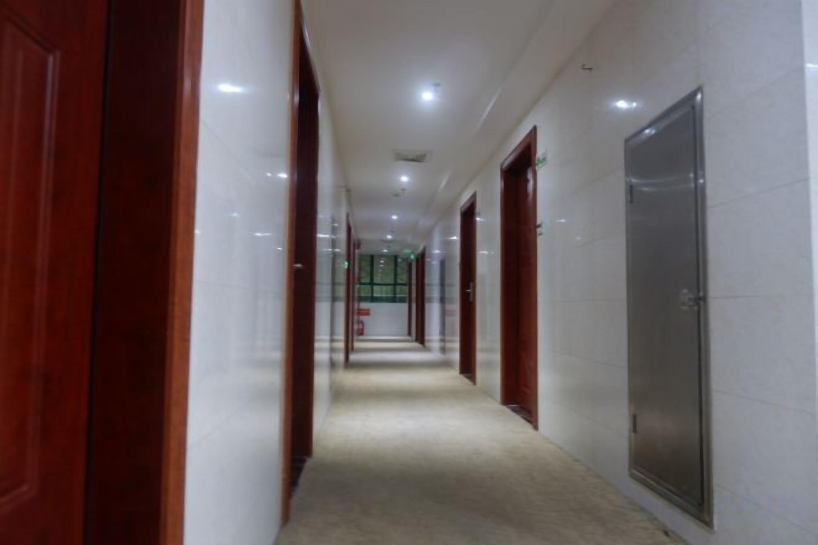 A corridor with doors on both sides, leading to rooms.